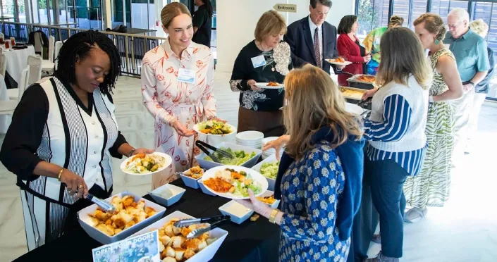 Coworkers serving themselves from a Post Exchange Catering buffet at an Atlanta corporate lunch